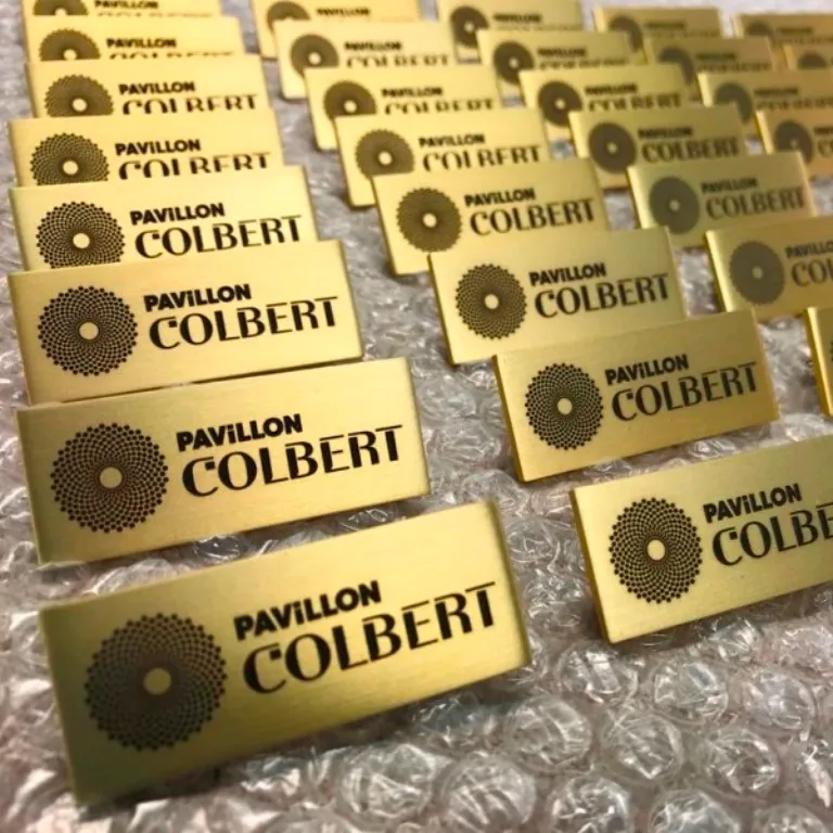 Série de badges nominatifs sur mesure en finition laiton brossé gravés au laser avec logo