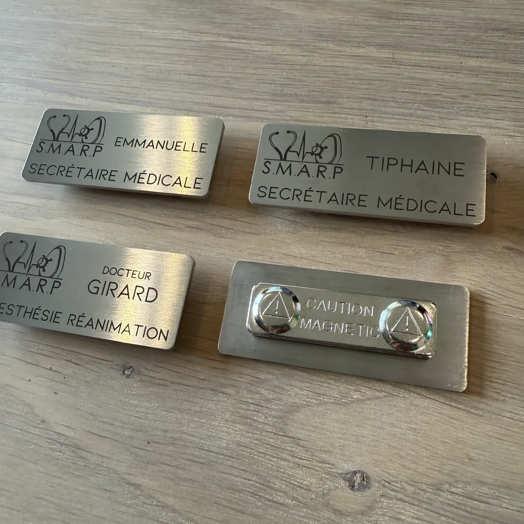 Badges nominatifs effet laiton brossé gravés au laser avec logo médical, pour personnel de cabinet, dont un retourné montrant son attache magnétique