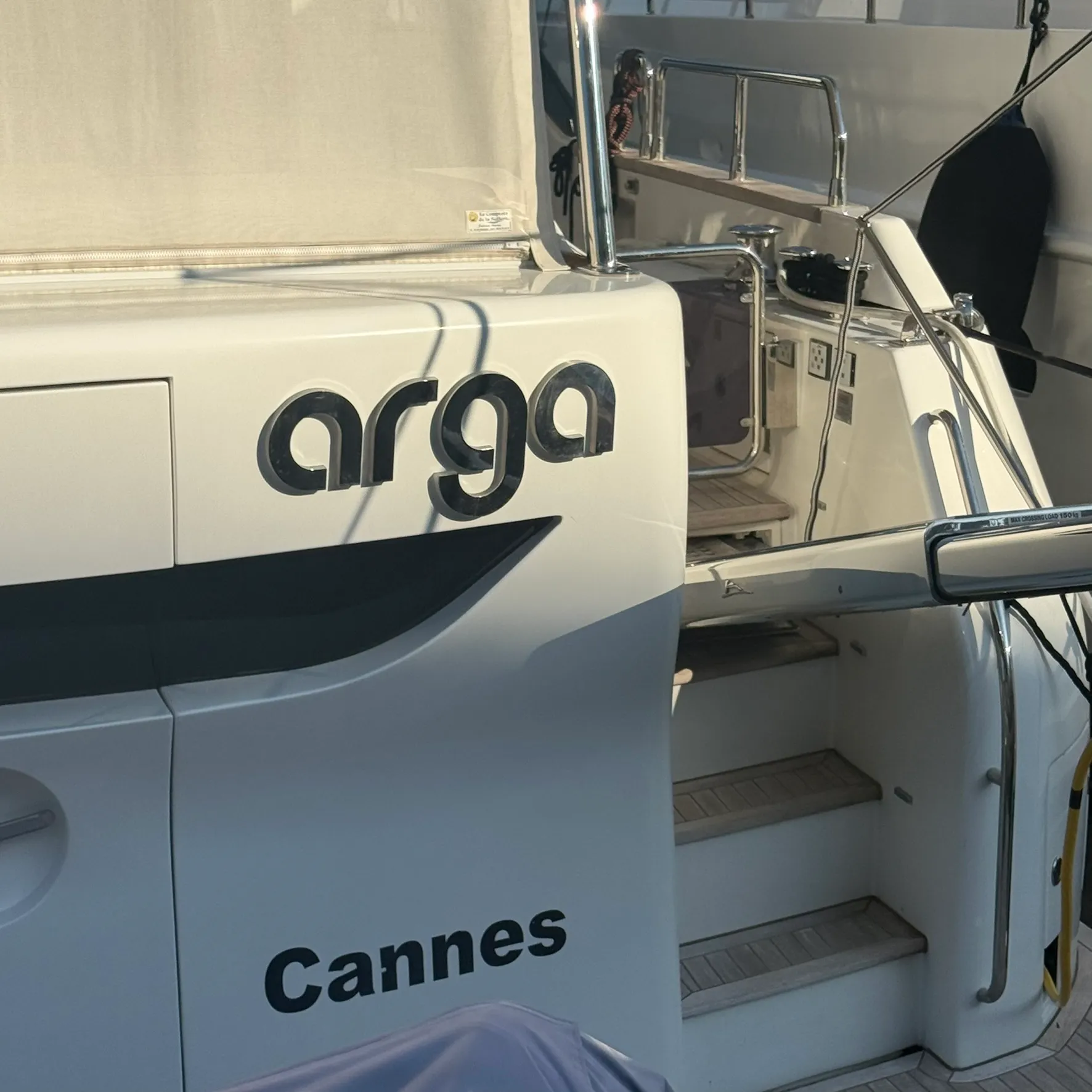 Enseigne de bateau « arga » en lettres relief inox poli fixées sur la coque d'un yacht immatriculé à Cannes