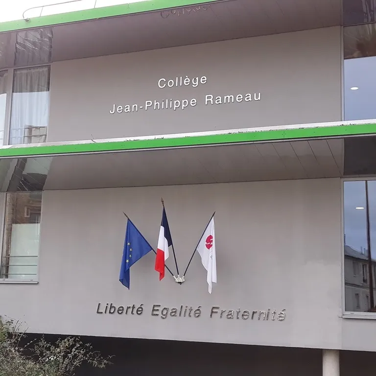 Enseigne d'établissement scolaire en lettres relief blanches sur façade béton, mention « Liberté Égalité Fraternité »
