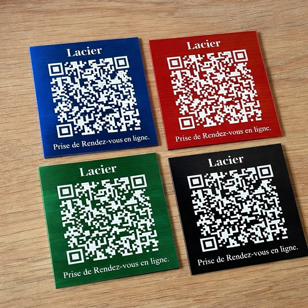 Quatre plaques carrées Lacier de prise de rendez-vous en ligne, en aluminium anodisé bleu, rouge, vert et noir, chacune gravée d'un QR code blanc